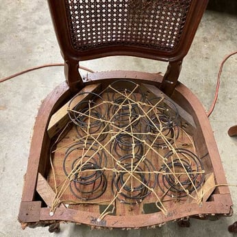 A chair with a mat caned back and an 8-way hand tied spring foundation seat - seat weaving and caning