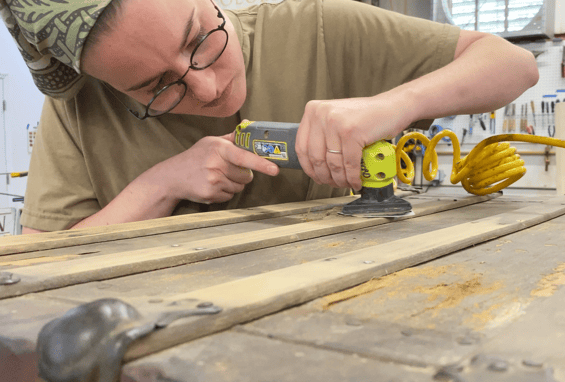 Craftsperson sands an antique trunk - trunk restoration