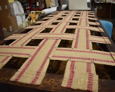 Example of Jute webbing repair on a walnut bench-upholstery services; raleigh, nc
