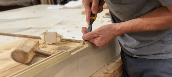 Carpenter chiselling wood- woodworking