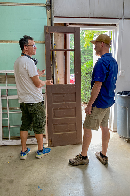 Cristian Morilla; master craftsman, and Zach Mumford, GM, evaluate an antique wood door for restoration