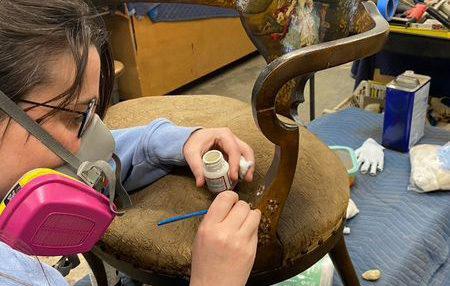 Lauren restoring painted chair at Mumford Restoration